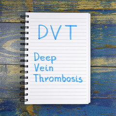 DVT- Deep Vein Thrombosis acronym written in notebook on wooden