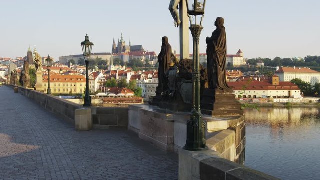 Rising shot on Charles Bridge of statues and Prague castle in the distance. 4k. 
