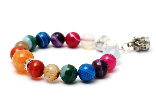 Colorful of agate,jasper bracelet decorate with silver crown pendant with white isolated background