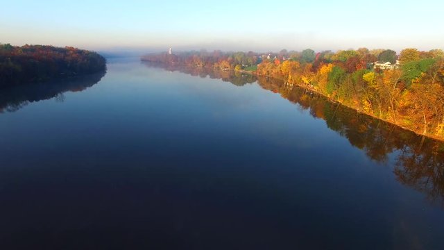 Scenic flight over foggy river with Autumn colors.

