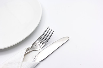 Knife and fork with serviette, isolated on the white background with copy space for text.