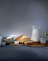 continental breakfast, dairy, jug, bread on a wooden board. space for text