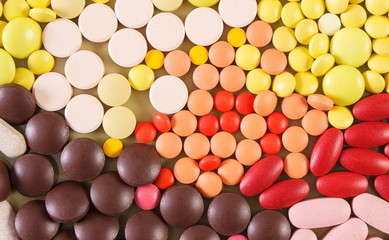 Colorful medical pills and capsules as background, health care concept