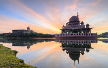 Fototapeta premium View and reflection of Putrajaya Mosque with stunning clouds and sky during sunrise