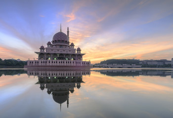Obraz premium View and reflection of Putrajaya Mosque with stunning clouds and sky during sunrise