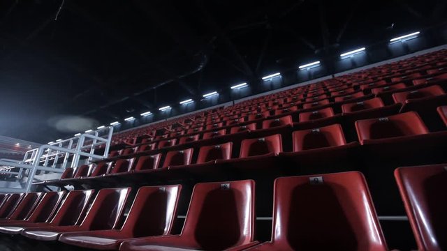 Camera moves among empty bleachers in a basketball arena