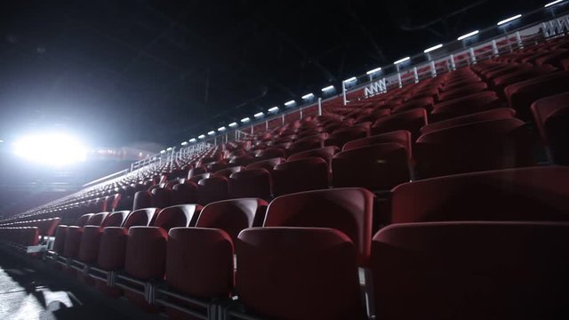 Camera moves among empty bleachers in a basketball arena