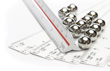 Ruler scale and ball bearings on white background