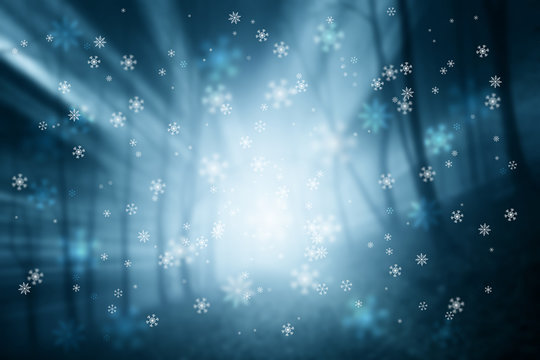 Abstract blurred foggy forest with snowflakes
