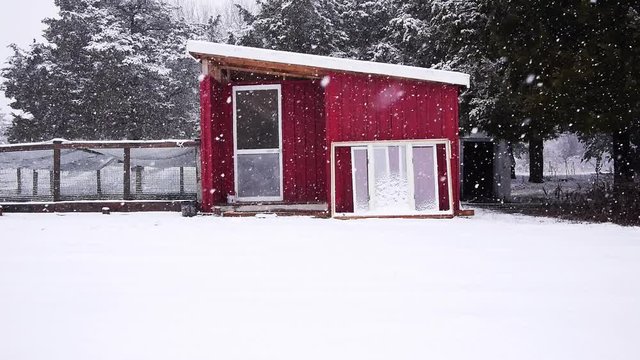 Small modern tiny home exterior during snowstorm, 