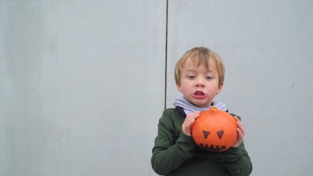 junger bub spielt mit k&uuml;rbis zu halloween