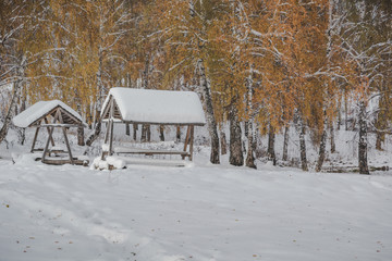 gazebo in winter woods on a background of lake