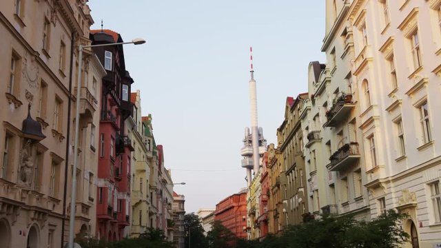 A right moving shot looking up at the street building facades with the Zizkov tower in the distance. 4k.