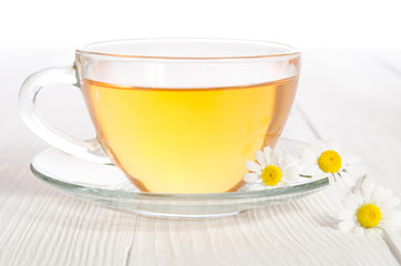 Cup of medicinal chamomile tea on the wooden table