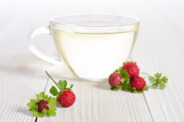 Cup of tea and strawbarries on the white wooden table