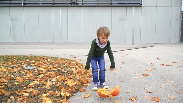 junger bub spielt mit k&uuml;rbis zu halloween