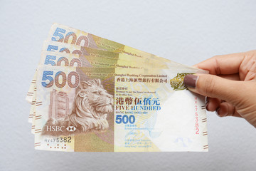 hand with Hong Kong dollar bills