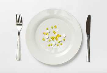 Pills on a plate on a white background