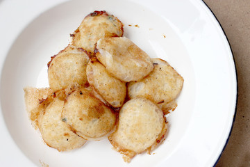 Kind of Thai sweetmeat , thai dessert, Thai coconut pudding. Kanom Krok stuffed with corn on cutting board with wooden table.