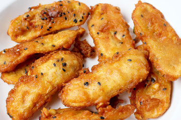 Fried Bananas sprinkled sesame tasty traditional food in white dish on wood table background. - Thai Snack