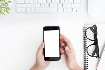 close up woman hand hold phone blank screen on white table