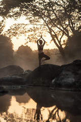 Young girl doing yoga fitness exercise outdoor in beautiful landscape. Morning sunrise,