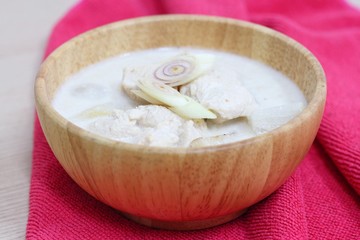 Thai sour chicken soup in wood bowl