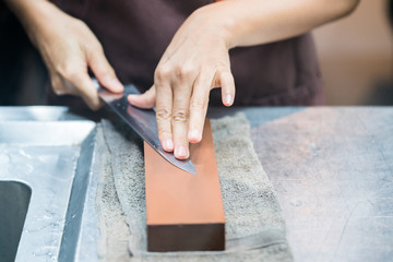 sharpening the knife with whetstone
