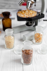 cereals in glass vials for analysis on wooden background