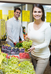 couple buying fresh seasonal fruits in market