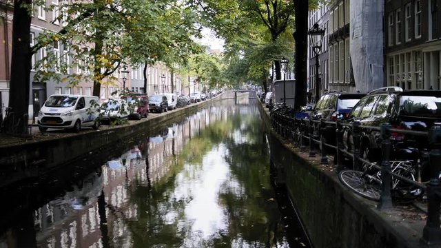 Amsterdam morning in center city - street with bicycles and cars on canal, Autumn, Netherlands