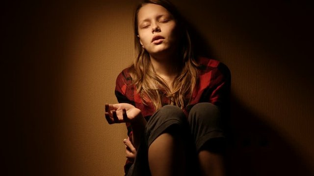 Teen girl. Drug addiction. Depressed face of a teen girl with overdose or hangover-abstinence syndrom from drugs. 4K