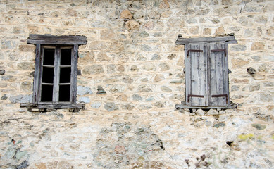 old Windows one open one closed on a destroyed wall