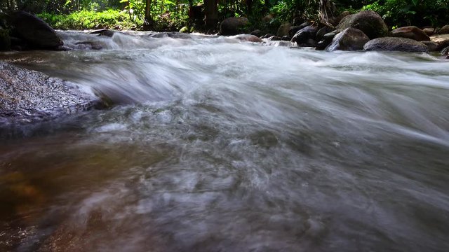 Beautiful silky water flow through stones,  Mountain stream running over rocks.