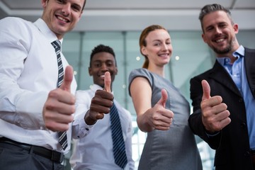 Business executive showing thumbs up in office