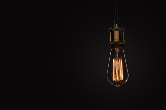 classic Edison light bulb on black background