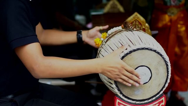 Musician playing 2 faces drum, Thai traditional musical instrument..