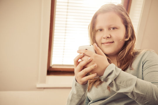 monochrome picture of a girl with her phone and smiling