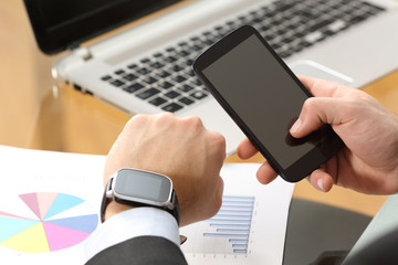 Businessman synchronizing a smart watch and phone