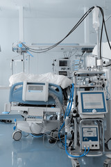 Hospital bed, surrounded by a mass of medical equipment