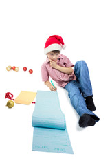 Boy writing a very long letter to Santa. Isolated on white background. Vertical orientation.