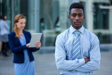 Businessman standing with arms crossed in office building