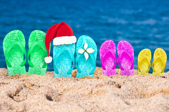 Christmas hat on flip flops in the sand of a beach
