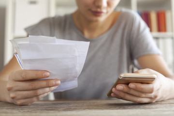 Woman hands with bills and mobile phone