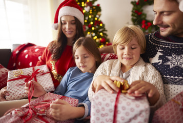 Fototapeta na wymiar Family opening Christmas presents at home