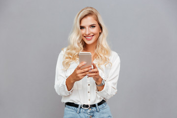 Smiling beautiful woman holding mobile phone