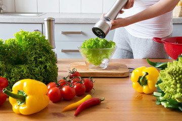 young woman making salad in the kitchen