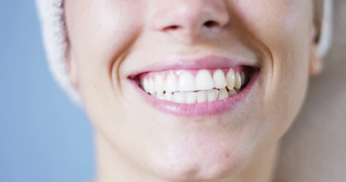 A girl over the shower brushing teeth with a toothbrush and toothpaste because it keeps us clean his mouth and wants to have white teeth and the 'fresh breath. smiles and passes his tongue between his