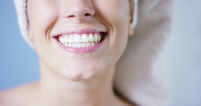 A girl over the shower brushing teeth with a toothbrush and toothpaste because it keeps us clean his mouth and wants to have white teeth and the 'fresh breath. smiles and passes his tongue between his