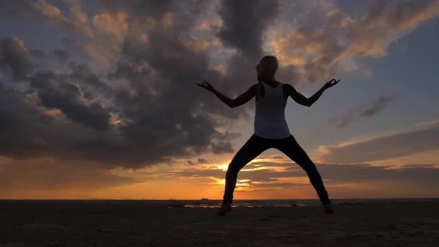 Woman Practicing Yoga at Sunset Beach